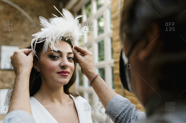 Beautiful bride having hair styled by male stylist at salon on wedding