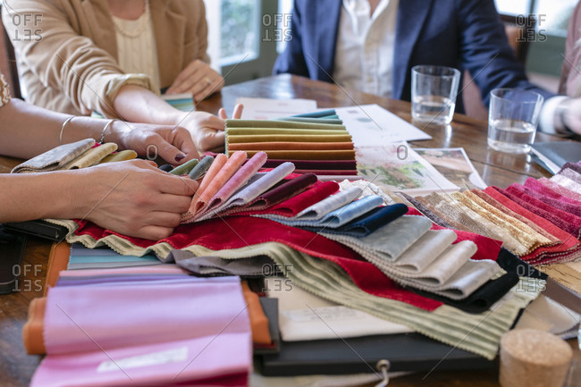 Couple choosing fabrics with event planner in her studio
