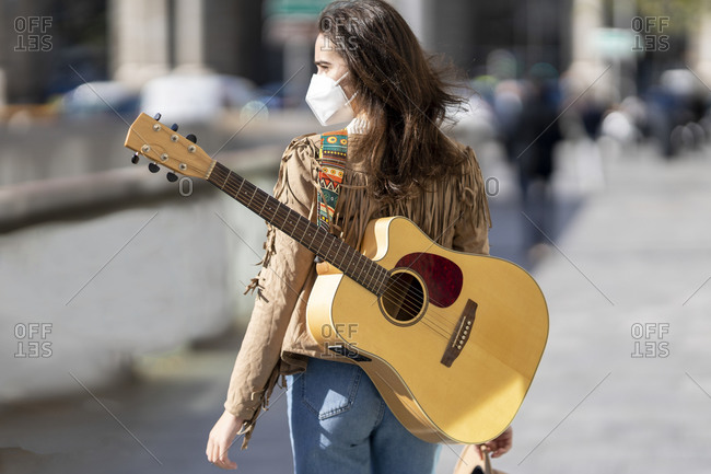 Female musician with guitar during pandemic
