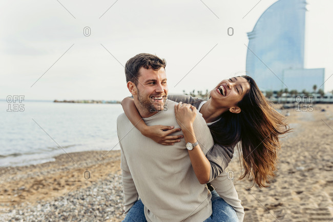 Free Photo  Man giving piggyback ride to woman on the beach