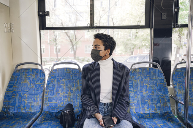 Young businesswoman traveling in bus during COVID-19