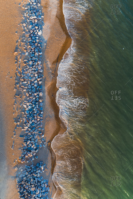 Aerial view of a beach, at sunset, with motion of waves, Barton On Sea, New Milton, Hampshire, United Kingdom