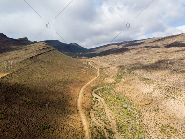Aerial view of Cederberg dirt road in the arid wilderness with clouds , Western Cape, South Africa
