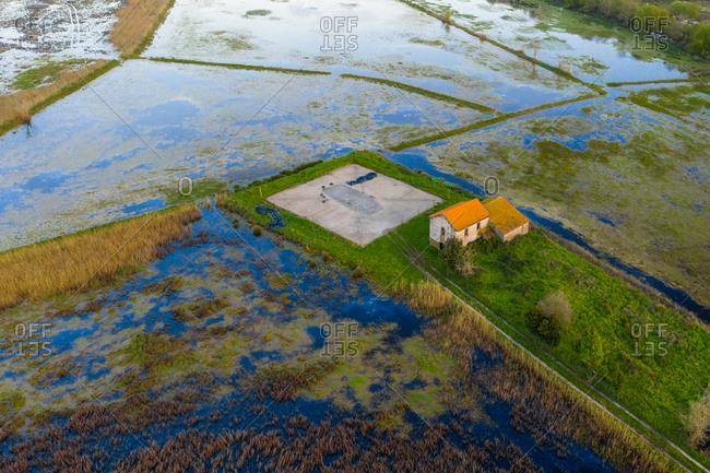Aerial view of a abandoned house in a marshland part of estuary of river Vouga, in Ria de Aveiro, Bioria, Salreu, Estarrega, Aveiro, Portugal