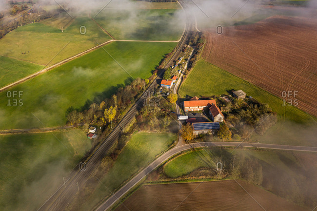 Panoramic aerial view of a rural autumn landscape with a fog layer covering a village, Hessia, Germany.