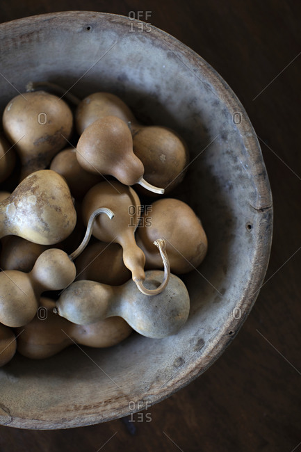 Handmade bowl filled with gourds on a woods table
