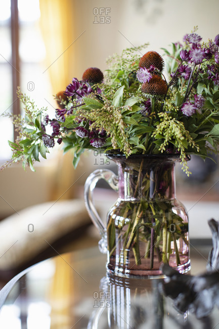 Floral arrangement in a vase on glass table