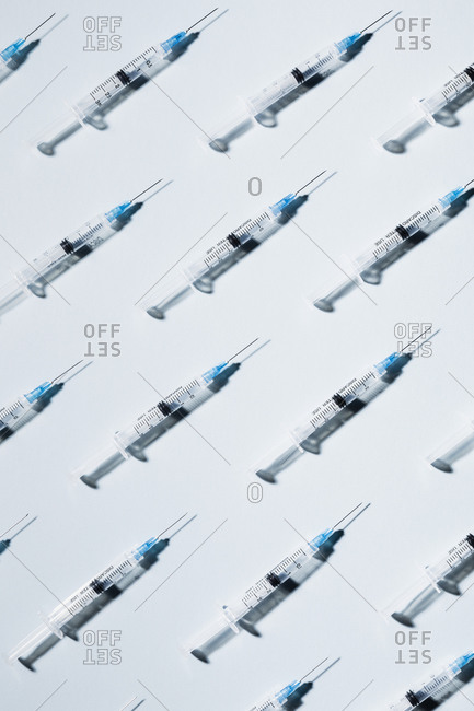 COVID-19 vaccine syringes on blue background