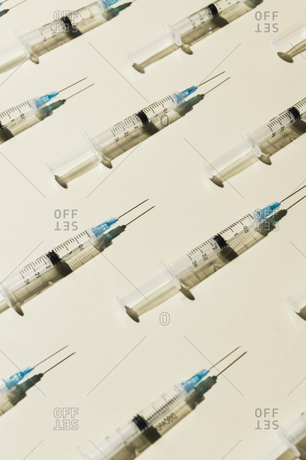 COVID-19 vaccine syringes on yellow background