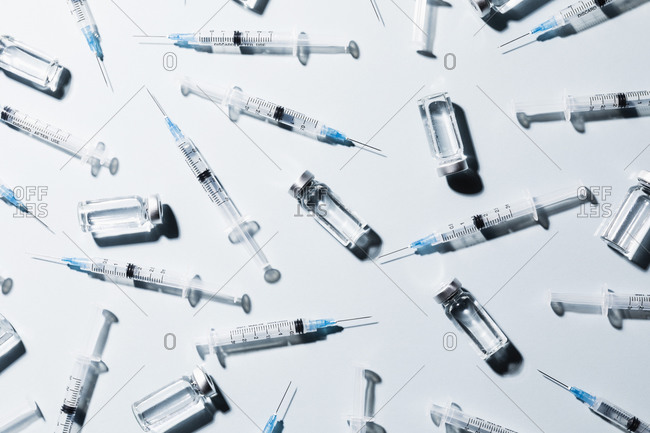COVID-19 vaccine vials and syringes on white background