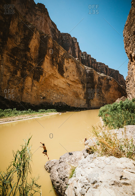 person jumping from rock into Rio Grande, Big Bend National Park