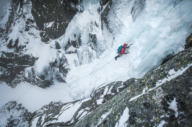 An alpine ice climber ascends a frozen gully in Maine