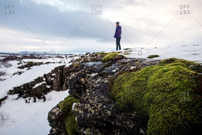 Person standing with rocks and moss in Thingvellir National Park