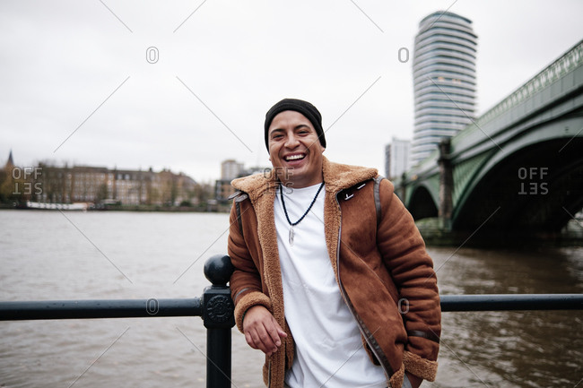 Latino man grinning at the camera outside next to the river