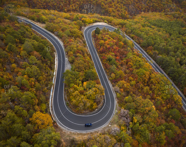 Aerial view to the road with a bend in the mountain at autumn