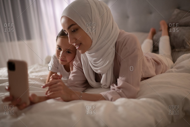 Muslim woman and girl talking with father online