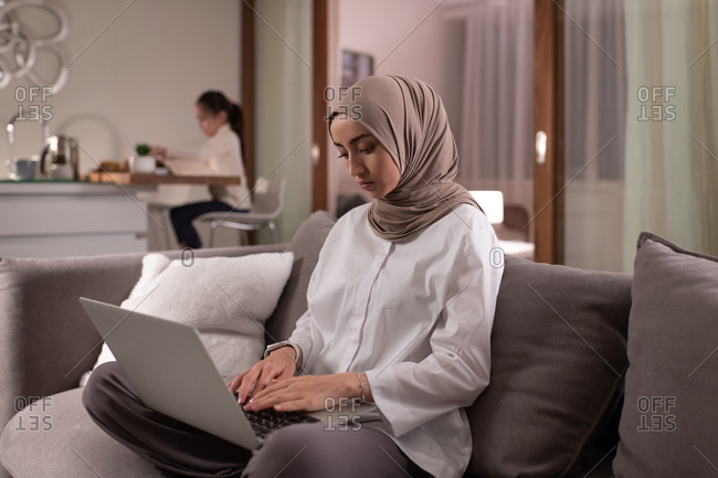 Muslim mother using laptop for work