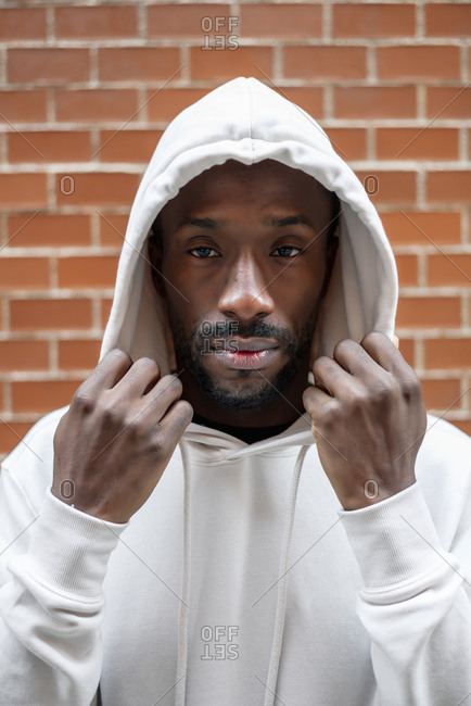 Front shot of African man with serious gesture covering his head with a white hood