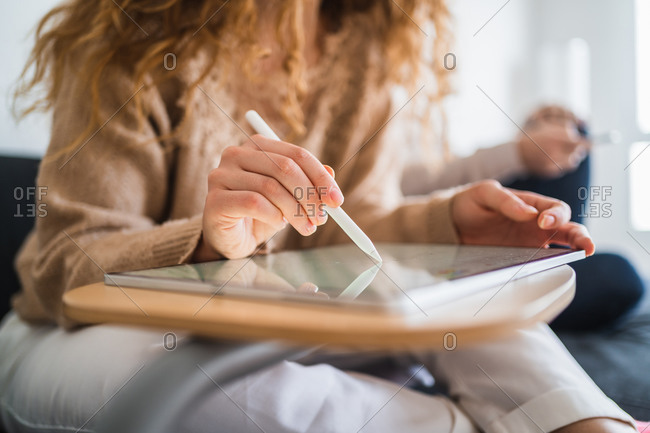Young anonymous designer girl drawing on tablet near boyfriend