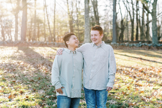 Portrait of mixed race brothers laughing in a park outdoors