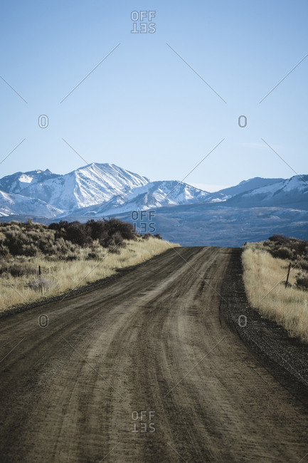 lonely dirt road leading snow capped mountains Black Canyon Colorado