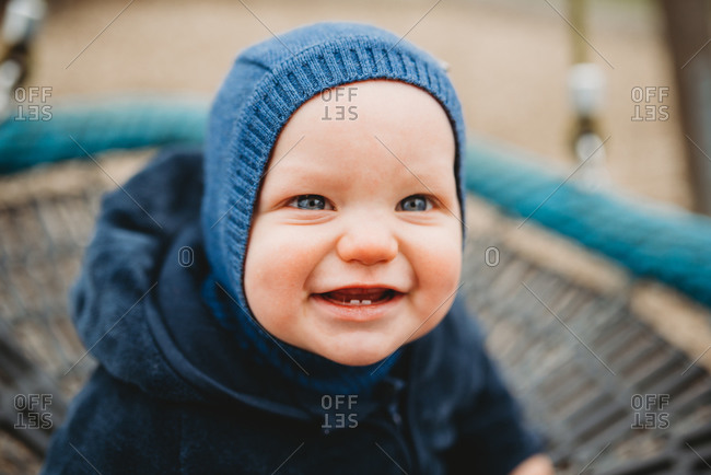 Adorable baby with two front teeth smiling outside in cold winter