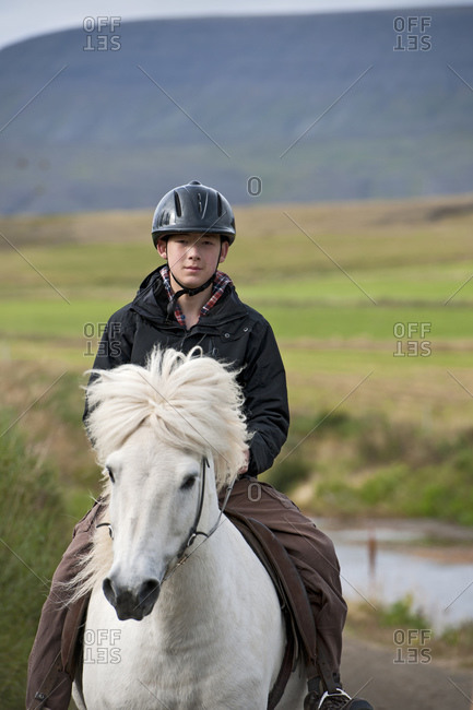 teenage boy riding Icelandic horse in remote location