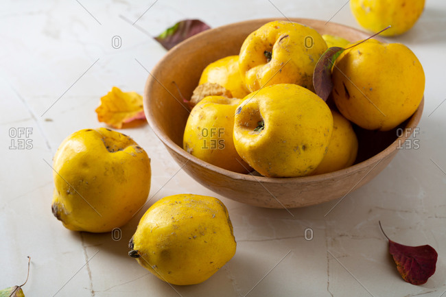 Close up of quinces in bowl on light table