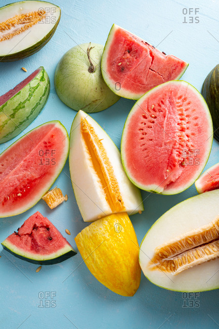 Melons and watermelon slices on light blue surface