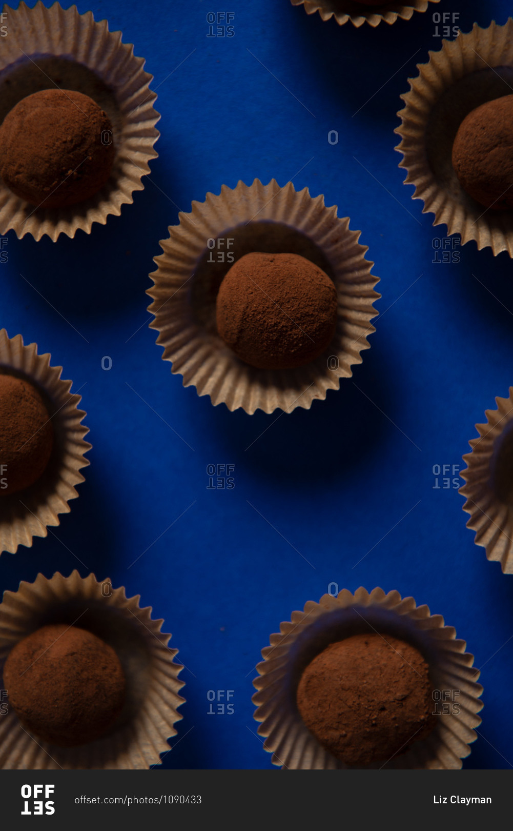Top view of many chocolate truffles on blue background