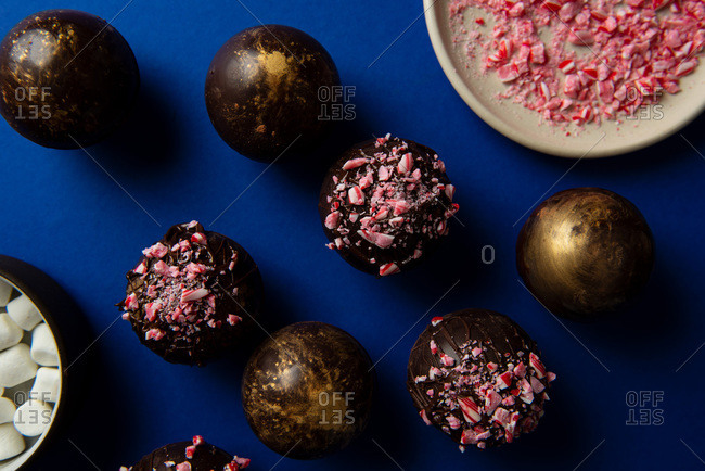 Hot chocolate bombs on blue background with ingredients