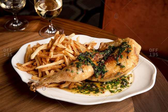 Plate of roasted chicken with herbs and French fries