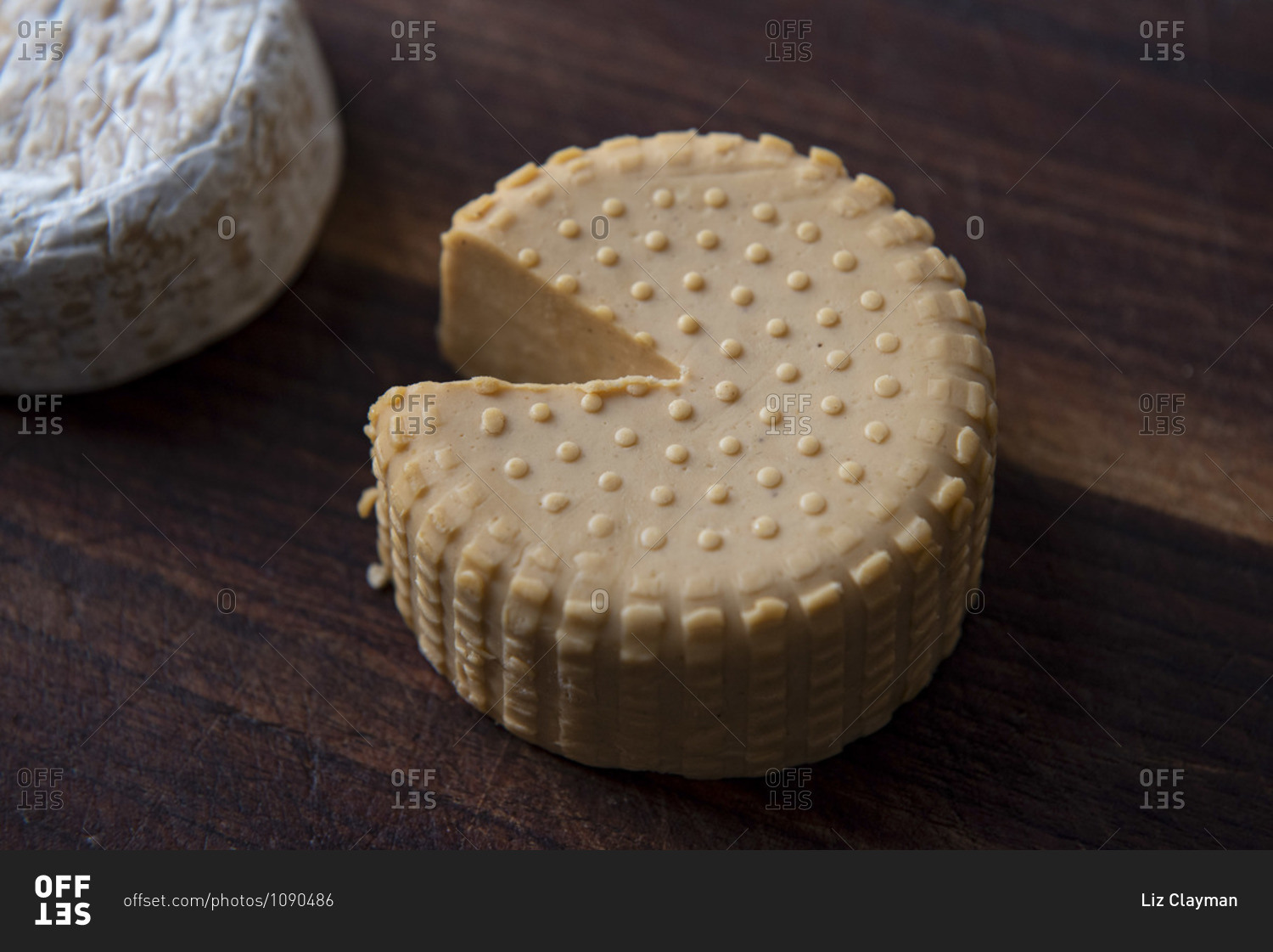 Top view of two plant based, dairy free cheeses on wooden board