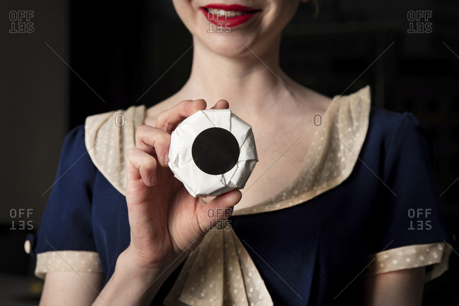 Woman holding wrapped wheel of cheese