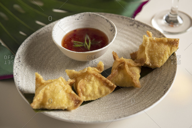 Plate of crab rangoons served with dipping sauce
