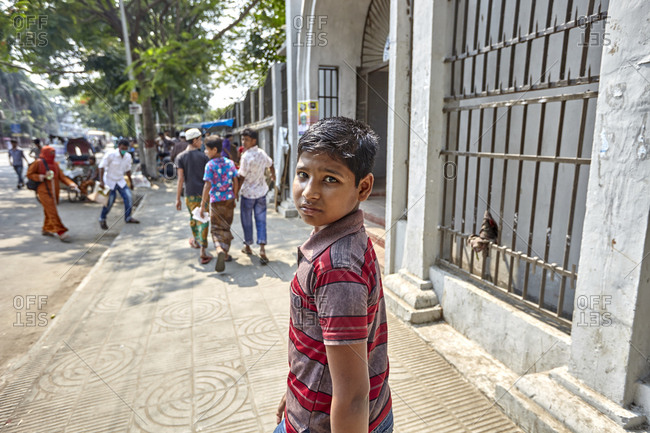 Dhaka, Bangladesh - April 26, 2013: A boy on a busy street in Dhaka, looking back at the camera