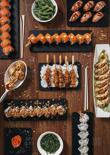 Top view of assorted sushi and rolls arranged on wooden table in restaurant with Asian food