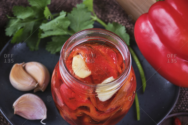 Vegan baked red peppers with garlic in crystal jar.