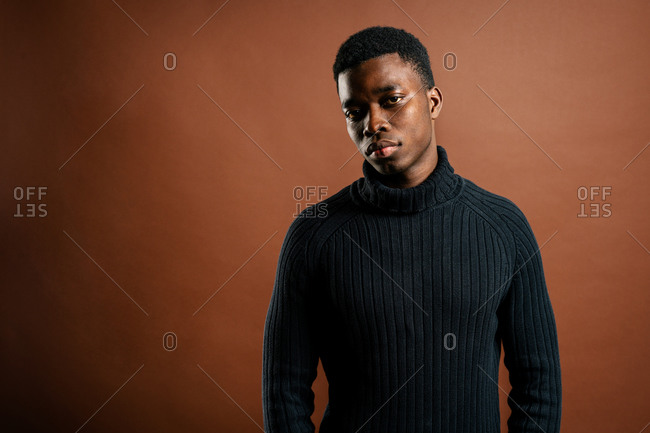 Thoughtful black man in casual outfit in studio