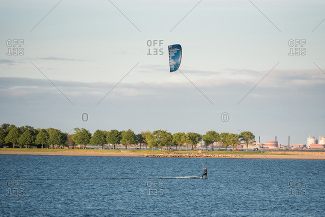 A woman kiteboarding in pleasure bay, boston on a summer afternoon