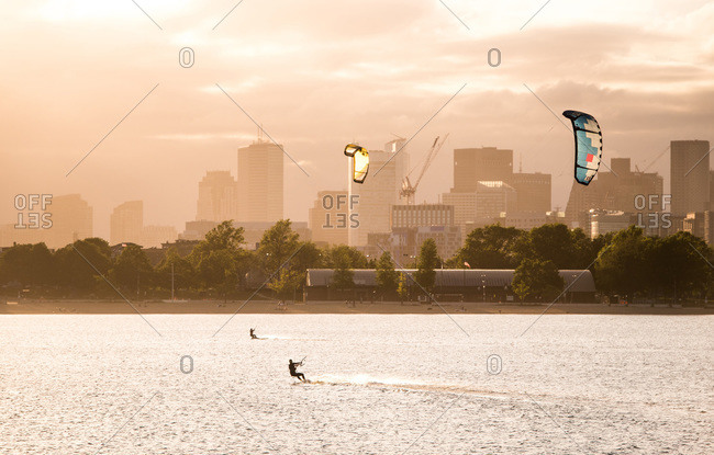 A woman kiteboarding on a summer afternoon with the boston skyline
