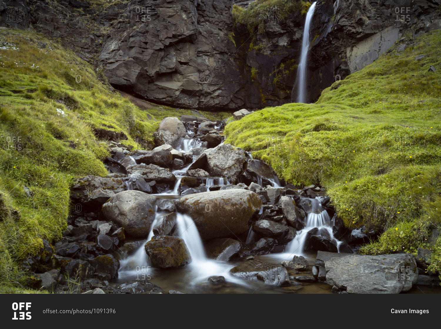 Low angle view of waterfall on mountain, eastern region, iceland