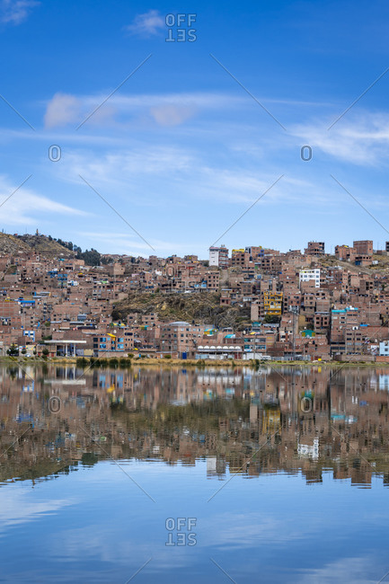 Reflections of houses in puno, lake titicaca, peru