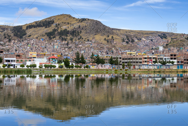 Reflections of houses in puno, lake titicaca, peru