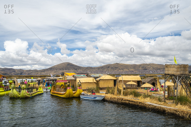 Puno, puno, peru - october 14, 2018: tourist boats made of reed moored at uros islands, lake titicaca, peru