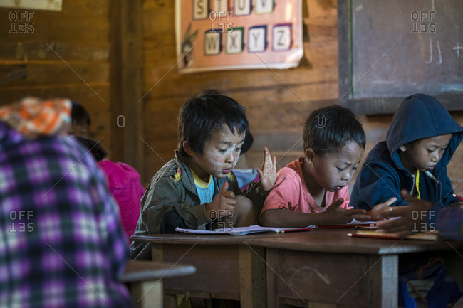 Loikaw, kayah state, myanmar (burma) - january 23, 2018: boys counting fingers while learning maths in elementary school at kayan village, loikaw, myanmar