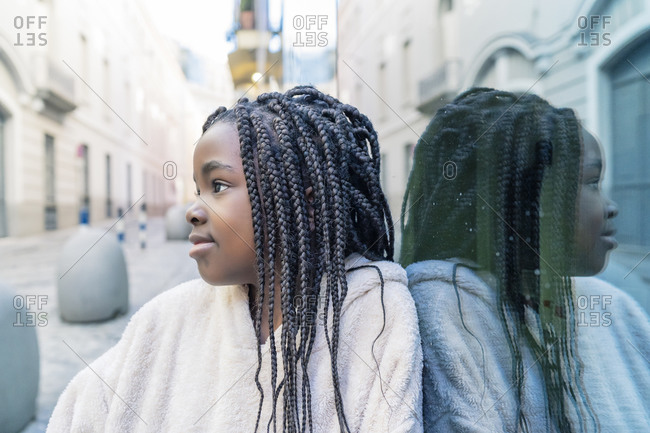 Beautiful african girl with braids on glass wall