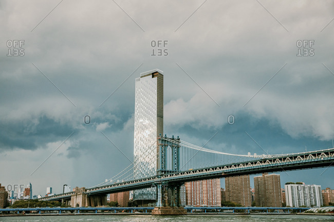 City skyline and manhattan bridge with storm clouds.