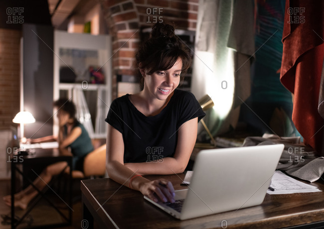 Female designer using laptop in workplace