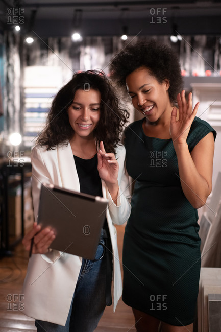 Cheerful smart businesswomen greeting coworker